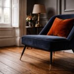 Modern vs traditional living room showcasing the mixing of modern and traditional styles, with a sleek velvet armchair on original wooden floorboards, soft layered lighting, and an out of focus Victorian sash window with shutters in the background.